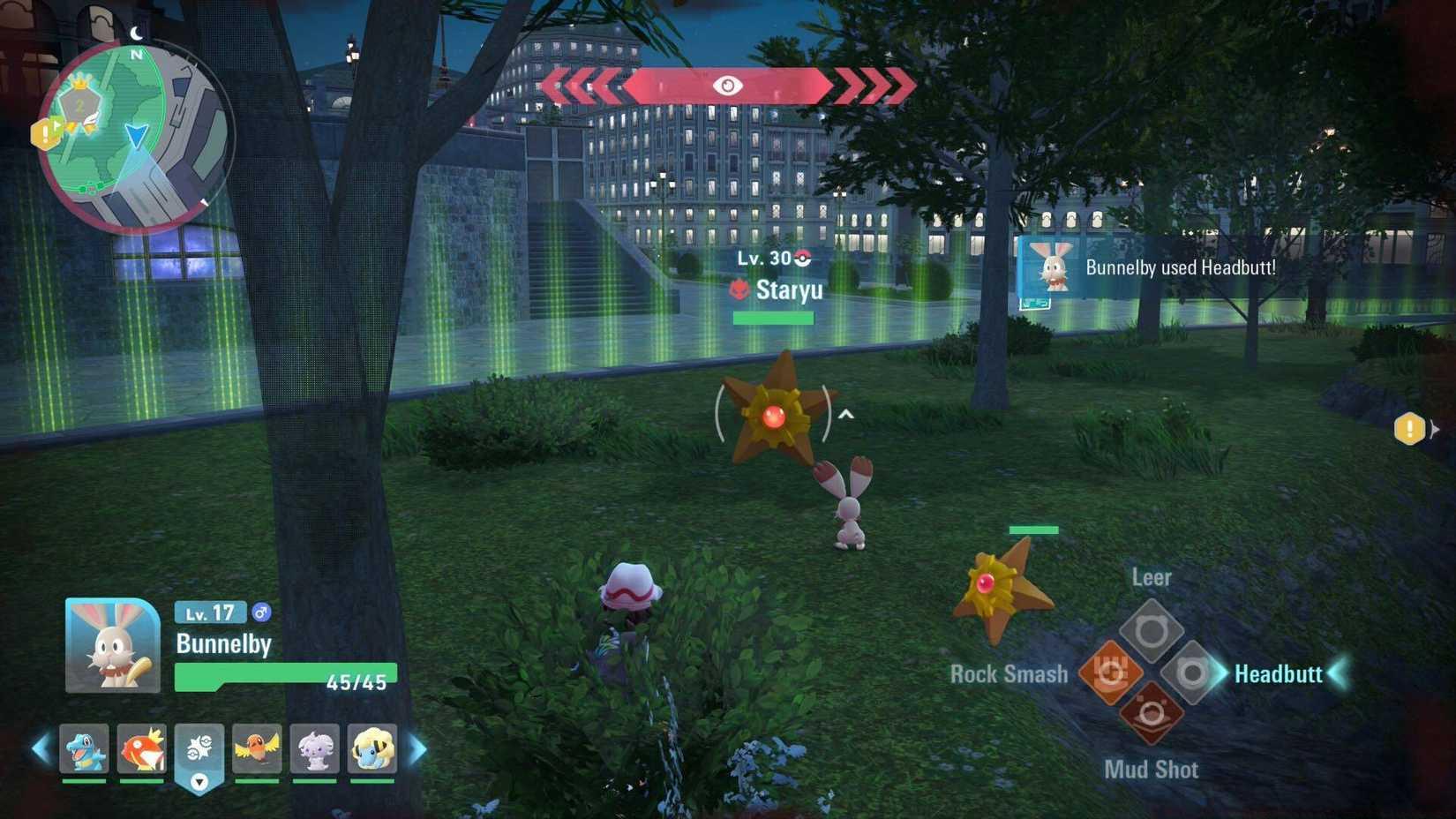 The player crouching in a bush as their Bunnelby prepares to attack alpha Staryu on land, wiht another Staryu jumping out of the water.